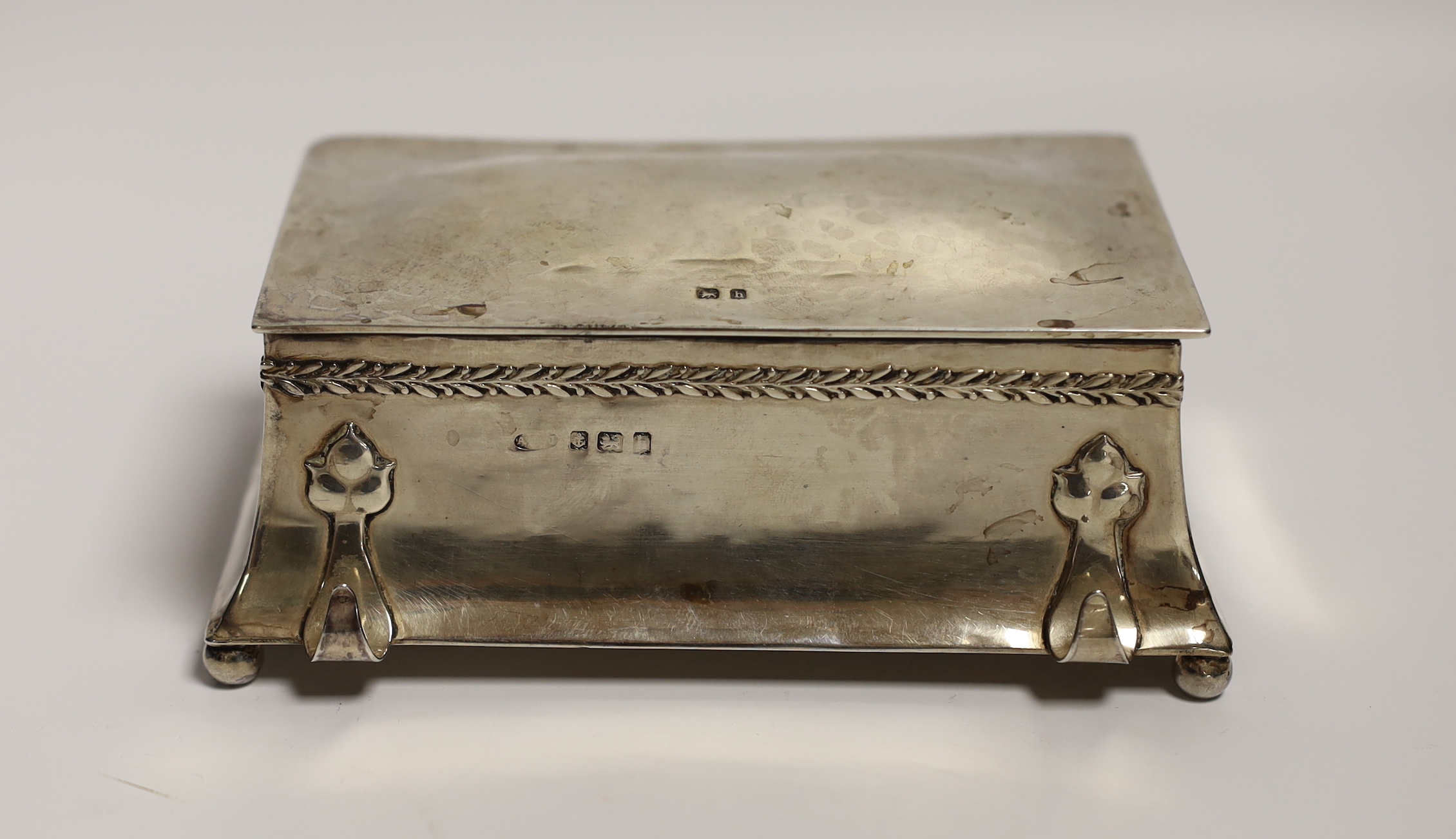 An Edwardian Arts and Crafts silver inkwell by Albert Edward Jones, with front pen rest and interior engraved inscription, Birmingham, 1907, 13.3cm.